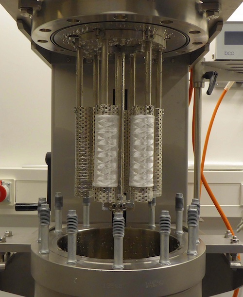 Treatment coils mounted in full configuration on the autoclave bracket. © 2026  DITF