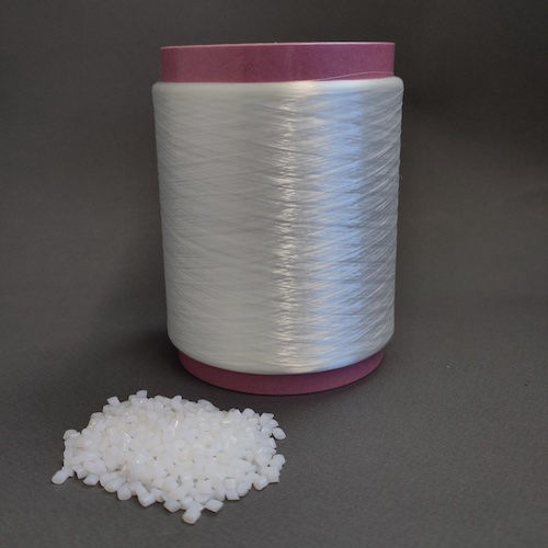 TPC granules with a spool of yarn, source: Institut für Textiltechnik (ITA) of RWTH Aachen University © 2026